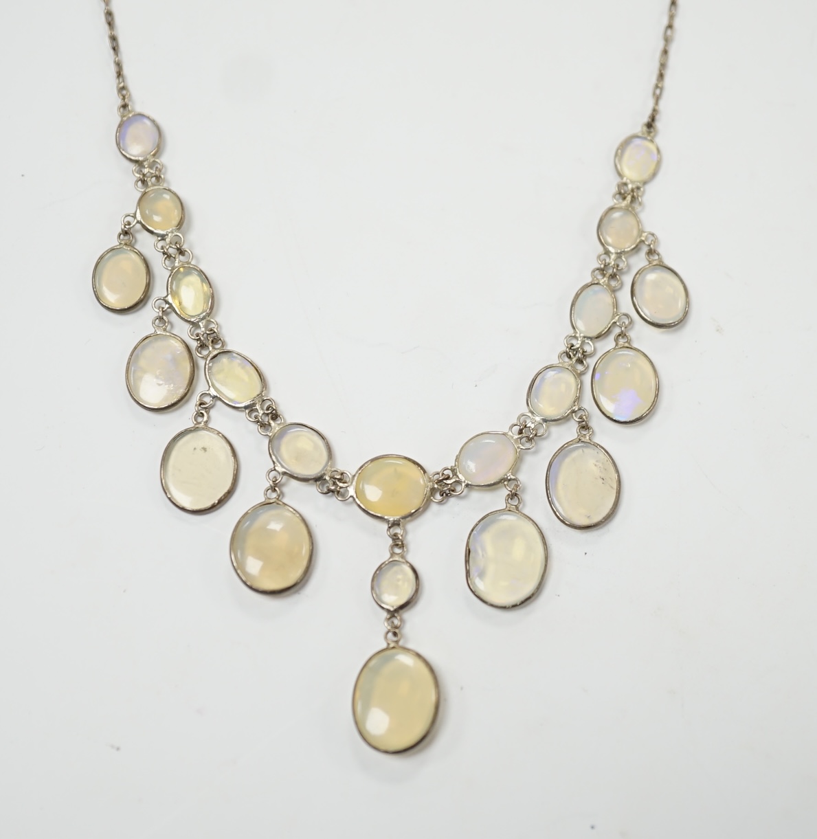 A white metal and graduated cabochon moonstone set drop necklace, 46cm. Condition - fair, one stone chipped